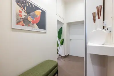 a living room with a green bench and a painting on the wall at Maison Trevi in Rome
