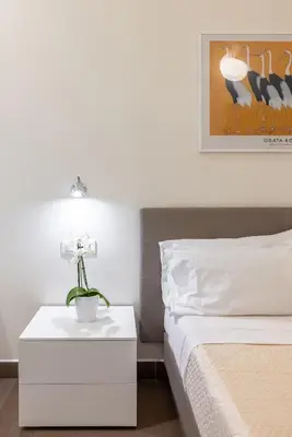 a bedroom with a bed and a table with a flower on it at Maison Trevi in Rome
