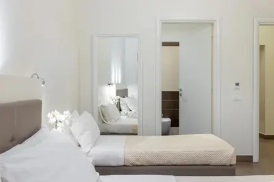 a bedroom with two beds and a mirror at Maison Trevi in Rome