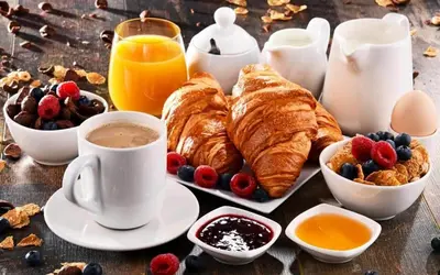 a table with a breakfast of croissants and coffee and fruit at AS Planet in Rome