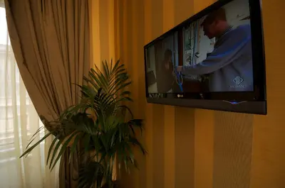 a television hanging on a wall with a man on it at AS Planet in Rome