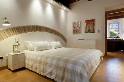 a bedroom with a large bed with a striped blanket at River View Apartment in Rome