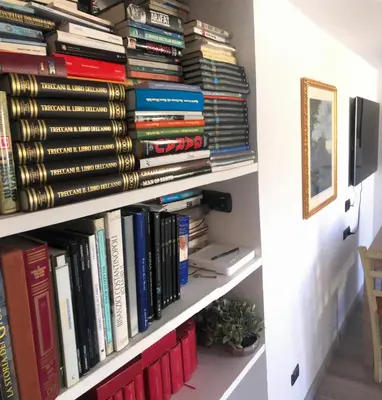 a book shelf filled with lots of books at Heart of Rome Vatican Deluxe New Apartment 1GB WiFi in Rome