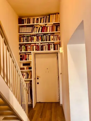 a hallway with bookshelves and a white door at Heart of Rome Vatican Deluxe New Apartment 1GB WiFi in Rome