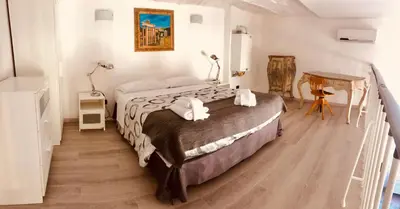 a bedroom with a large bed and a table at Heart of Rome Vatican Deluxe New Apartment 1GB WiFi in Rome