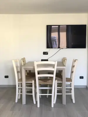 a white table and chairs with a television on a wall at Heart of Rome Vatican Deluxe New Apartment 1GB WiFi in Rome