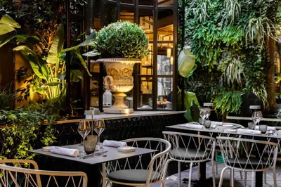 a restaurant with two tables with chairs and a vase at Roma Luxus Hotel in Rome