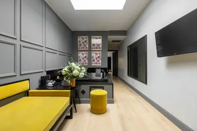 a living room with yellow couches and a piano at Roma Luxus Hotel in Rome