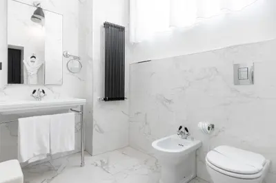 a room with a bed and two chairs and a table at Roma Luxus Hotel in Rome