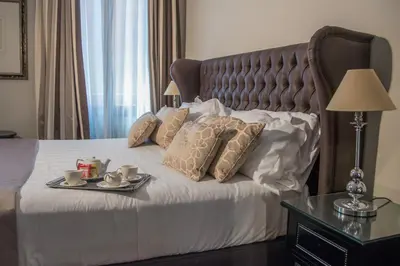 a hotel room with a bed with a tray of food on it at Hotel Monte Cenci in Rome
