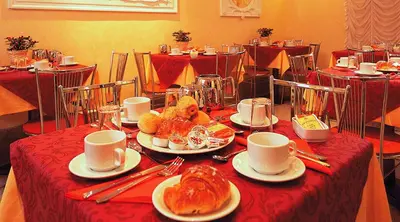 a table with plates of croissants and cups on it at Hotel Stromboli in Rome