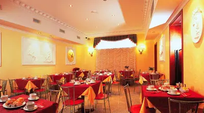 a restaurant with tables and chairs with red table cloth at Hotel Stromboli in Rome