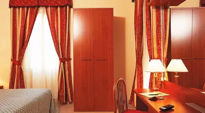 a hotel room with a bed and a desk with a desk at Hotel Stromboli in Rome