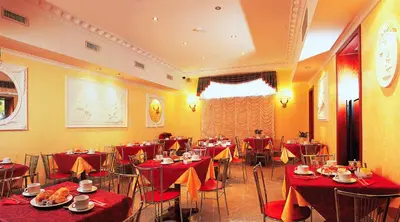 a dining room with tables and chairs with red table cloth at Hotel Stromboli in Rome