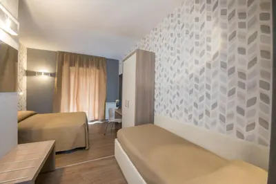 a hotel room with two beds and a table at B&B Fantasie Romane in Rome