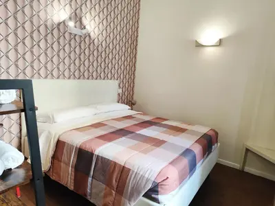 a bedroom with a bed with a colorful blanket at Milazzo23 Guesthouse in Rome