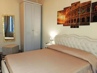 a bedroom with a bed and a painting on the wall at Colosseum Suite in Rome