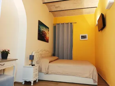 a bedroom with a bed and a yellow wall at Colosseum Suite in Rome