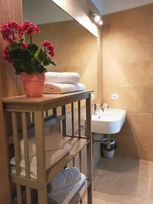 a bathroom with a sink and a shelf with towels at Colosseum Suite in Rome