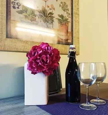 a table with two glasses and a bottle of wine at Colosseum Suite in Rome