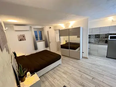 a bedroom with a large bed and a kitchen at Colosseum Suite in Rome