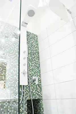 a shower with green and white tiles in a bathroom at Like Family House in Rome
