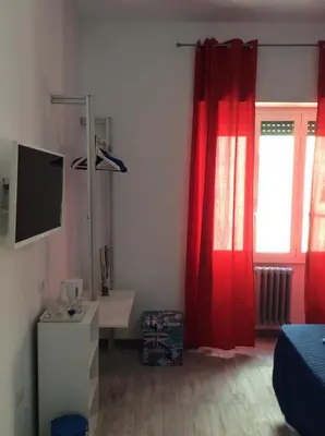 a room with a red curtain and a window at Like Family House in Rome