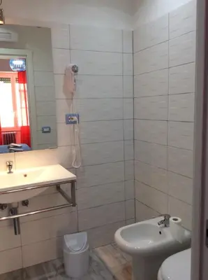 a bathroom with a sink and a toilet and a mirror at Like Family House in Rome