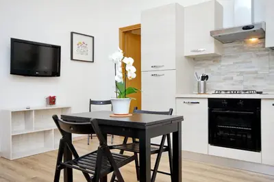 a kitchen with a table and two chairs and a tv at Holiday rental San Lorenzo district in Rome