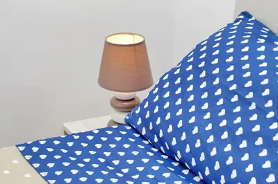 a bed with a blue and white pillow and a lamp at Holiday rental San Lorenzo district in Rome