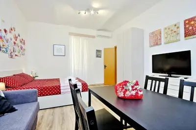 a living room with a dining table and a bedroom at Holiday rental San Lorenzo district in Rome