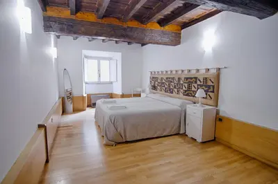 a bedroom with a bed and a wooden floor at Rinidia - Roma Centro in Rome