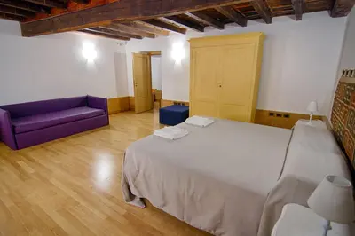 a bedroom with a large bed and a purple couch at Rinidia - Roma Centro in Rome