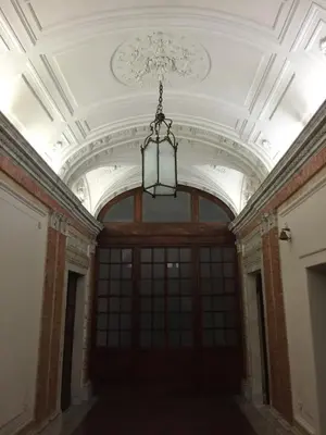 an empty room with a chandelier hanging from a ceiling at Rinidia - Roma Centro in Rome