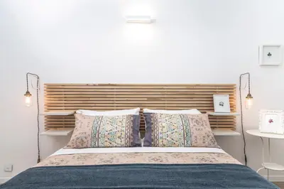 a bedroom with a bed with a wooden headboard and pillows at Interno 6 San Pietro in Rome