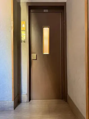 a brown door in a hallway with a window at Casa Blaserna nel Cuore dello Shopping a Marconi e Trastevere in Rome