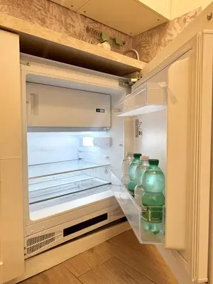a refrigerator filled with lots of green glass jars at Casa Blaserna nel Cuore dello Shopping a Marconi e Trastevere in Rome