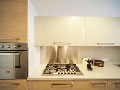 a kitchen with a stove top oven and cabinets at Roman Home Base in the Appio Latino in Rome