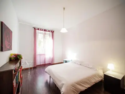 a white bedroom with a large bed and a window at Roman Home Base in the Appio Latino in Rome