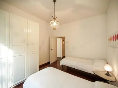 a bedroom with two beds and a chandelier at Roman Home Base in the Appio Latino in Rome