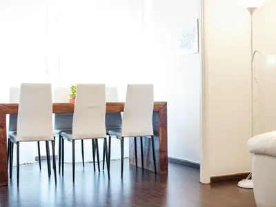 a dining room table with white chairs around it at Roman Home Base in the Appio Latino in Rome