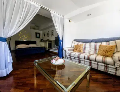 a living room with a couch and a glass table at Frattina Family Romantic Superior Suite in Rome