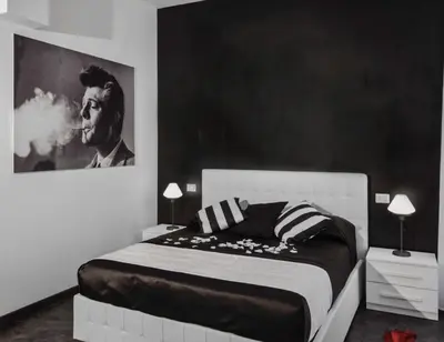 a black and white bedroom with a bed and a picture at Good Life Via Veneto in Rome