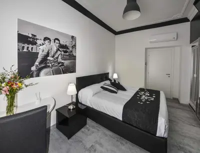 a black and white bedroom with a bed and a bathroom at Good Life Via Veneto in Rome