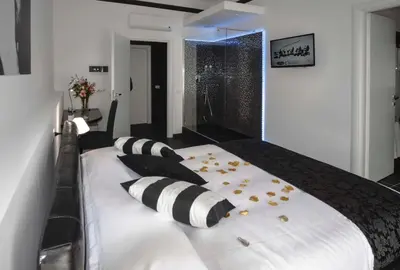 a large white bed with black and white pillows at Good Life Via Veneto in Rome