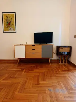 a living room with a tv and a wooden floor at RoRo Roma in Rome