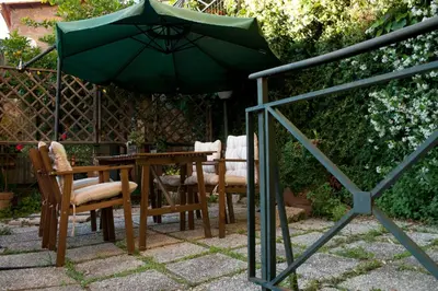 a table and chairs with a green umbrella at Le Scalette in Rome