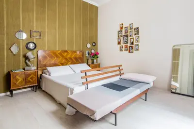 a bedroom with two beds and a table and a mirror at Dandy Suite in Rome