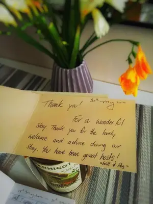 a note on a table with a vase of flowers at Dandy Suite in Rome