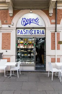 a restaurant with tables and chairs in front of a store at Dandy Suite in Rome
